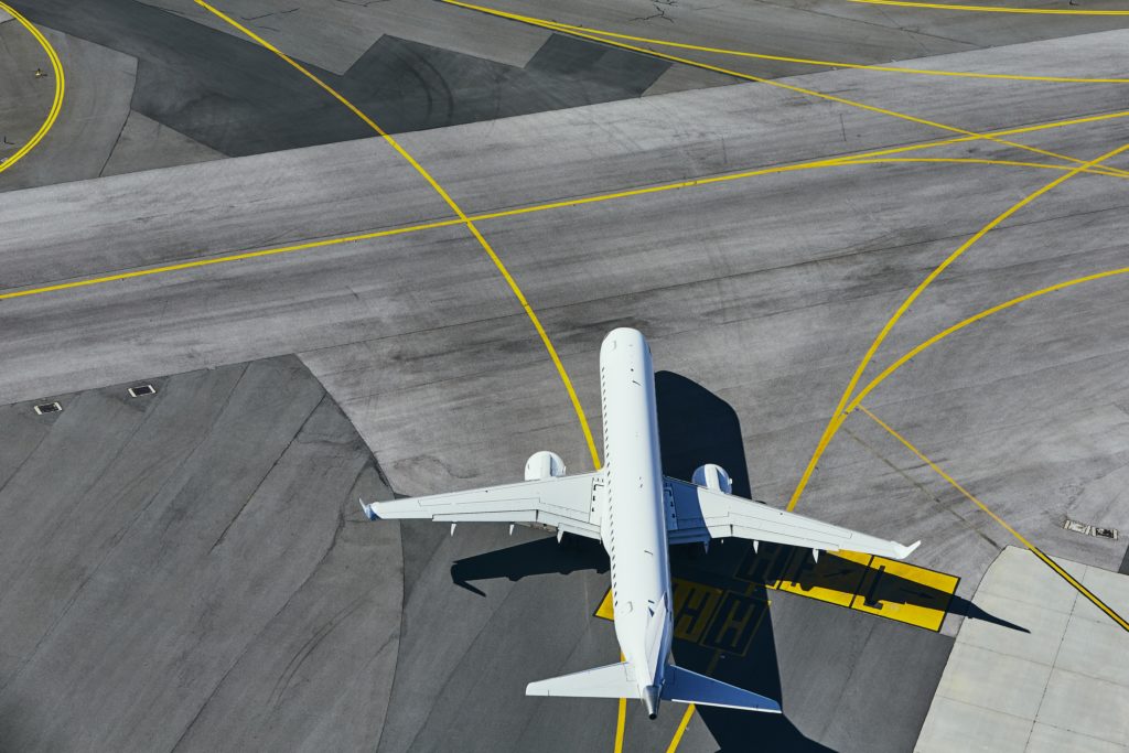 Aerial view of the airport. Airplane taxiing to runway.