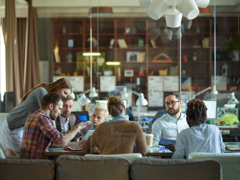 Group of modern employees discussing data