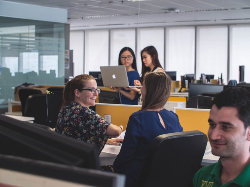 An open office space with pairs of people talking and collaborating. 