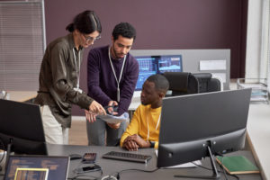 Three people collaborating on project in IT development office