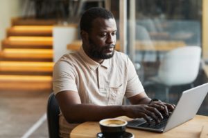 man using laptop in cafe