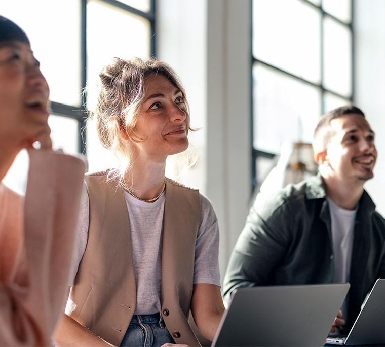 woman at a group seminar looks up and smiles