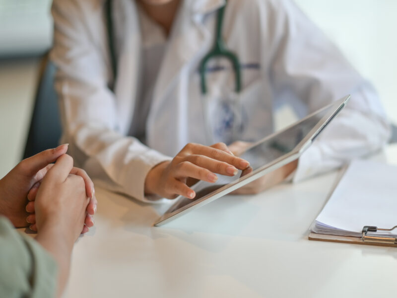 Shot of a doctor showing a patient some information on a digital tablet