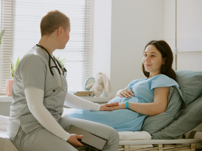 Nurse sitting next to pregnant patient