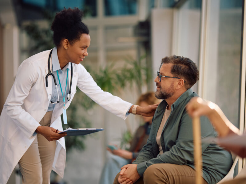 Woman doctor consulting with male patient at hospital