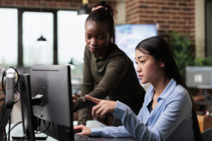 Creative and diverse office people reviewing 3D project progress while solving graphical issues.